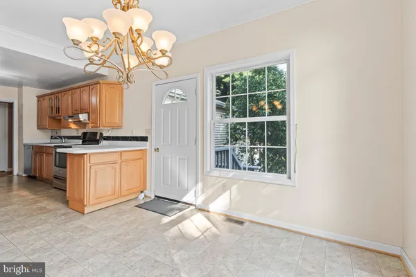 a kitchen with a stove a refrigerator and a chandelier