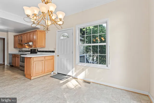 a kitchen with a stove a refrigerator and a chandelier
