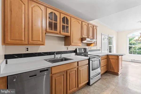 a kitchen with stainless steel appliances granite countertop a sink stove and cabinets
