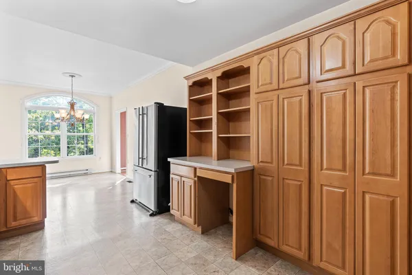 a view of kitchen with stainless steel appliances wooden cabinet and a window