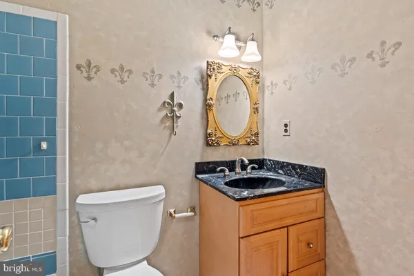a bathroom with a granite countertop toilet sink and mirror