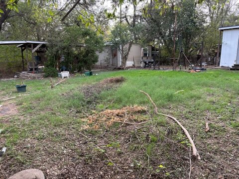 7802 Persimmon Trail Austin, TX 78745 - Photo 5 of 7 a view of a wooden house with a yard and trees