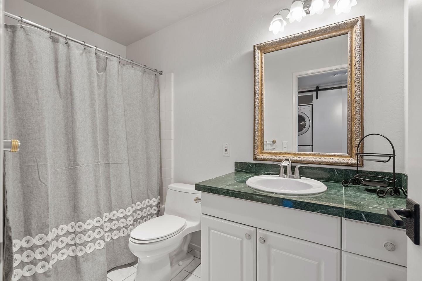 320 Vallejo Drive, Unit 41 Millbrae, CA 94030 - Photo 27 of 37 a bathroom with a granite countertop sink and a mirror with toilet