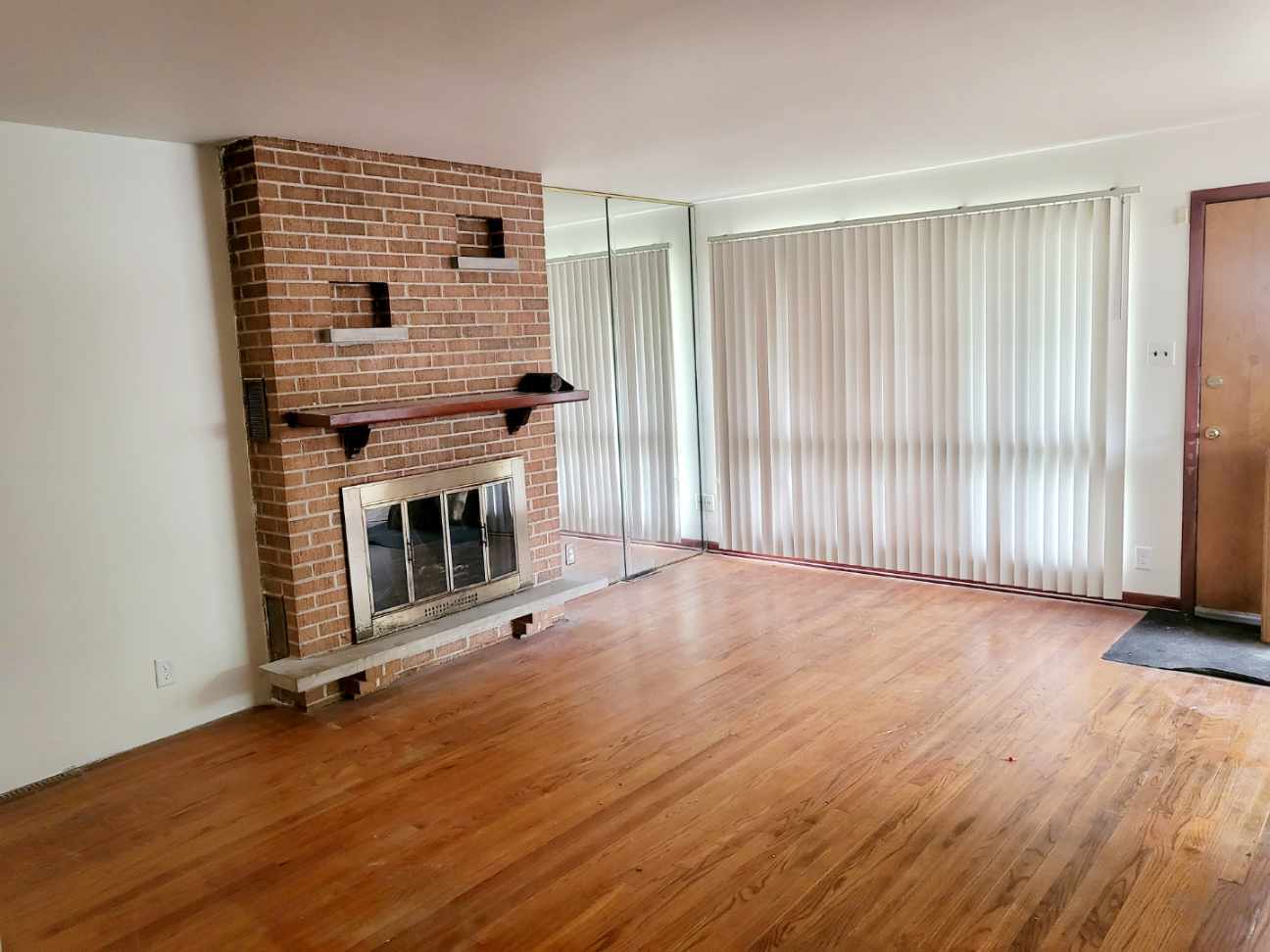 15041 Cottage Grove Avenue Dolton, IL 60419 - Photo 2 of 11 an empty room with wooden floor fireplace and windows