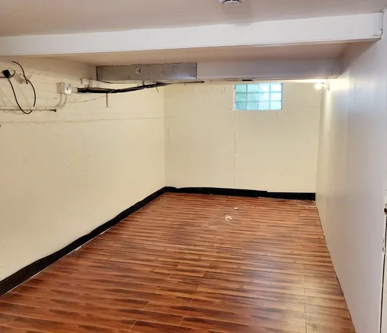 a view of an empty room with wooden floor and entryway
