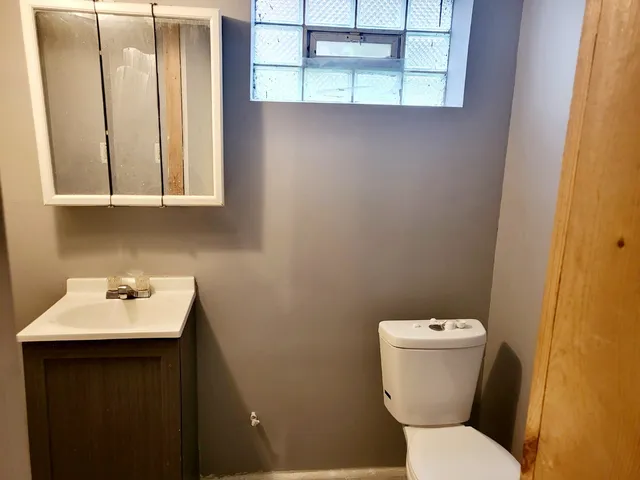 a bathroom with a toilet sink and mirror