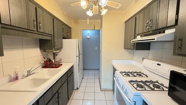 a kitchen with a sink a stove and cabinets