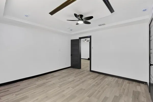 a view of an empty room with wooden floor