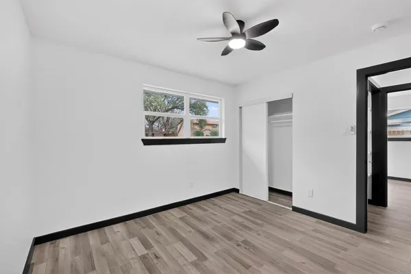 a view of empty room with wooden floor