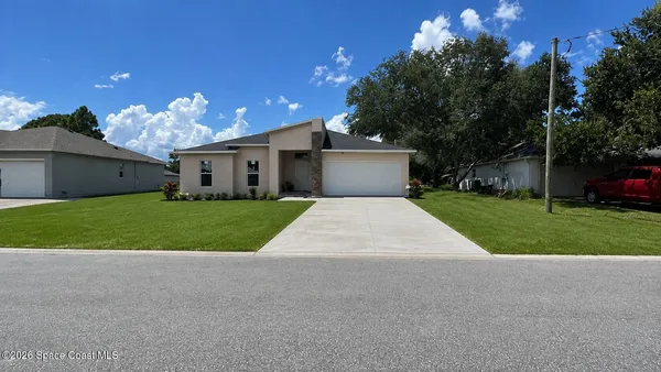 a front view of house with yard and green space