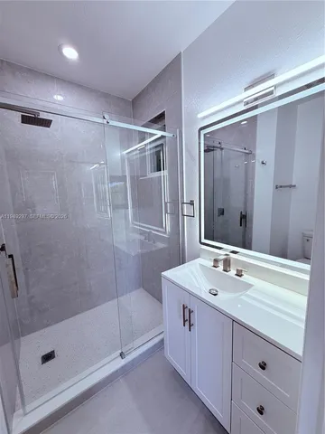 a bathroom with a shower sink and mirror