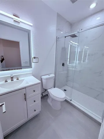 a bathroom with a toilet sink shower and mirror