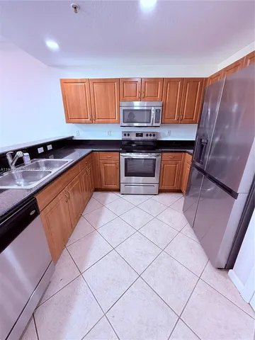a kitchen with stainless steel appliances a stove a sink and a microwave