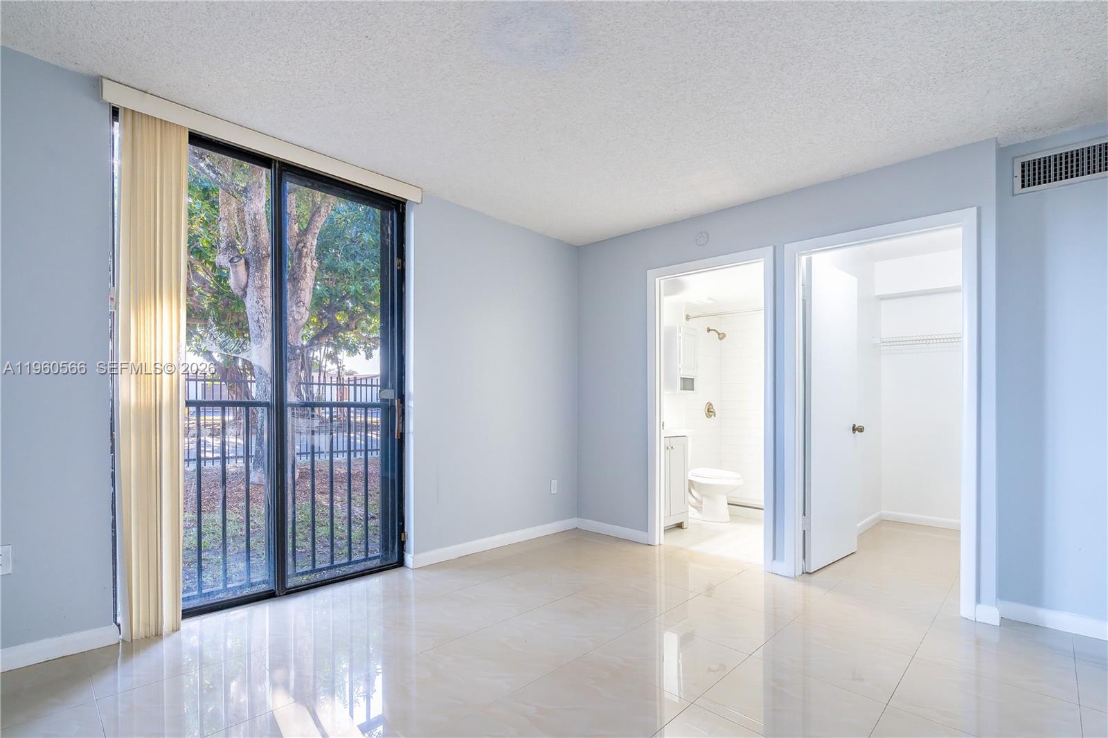 6795 Southwest 132nd Avenue, Unit 101 Miami, FL 33183 - Photo 20 of 37 a view of a big room with windows and wooden floor