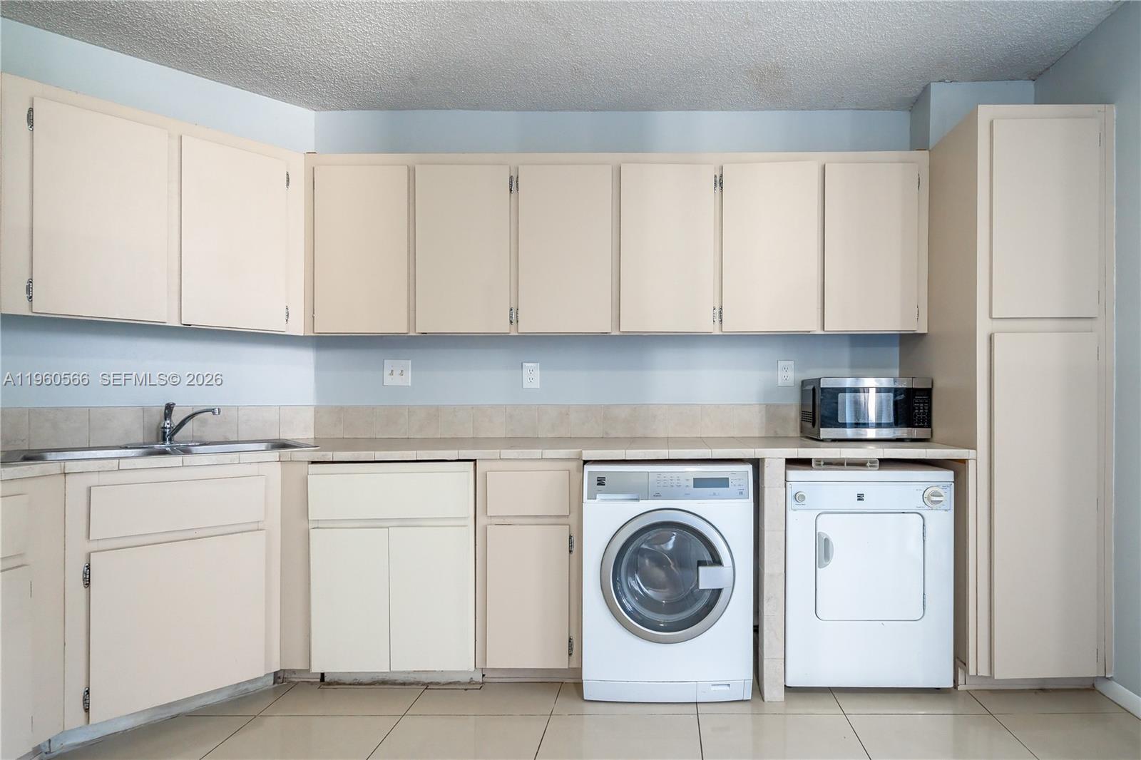 6795 Southwest 132nd Avenue, Unit 101 Miami, FL 33183 - Photo 32 of 37 a kitchen with white cabinets and white appliances
