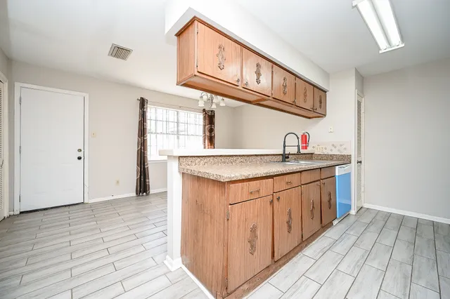a kitchen with stainless steel appliances granite countertop a sink and dishwasher with wooden cabinets