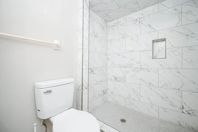 a white toilet sitting next to a bath tub shower