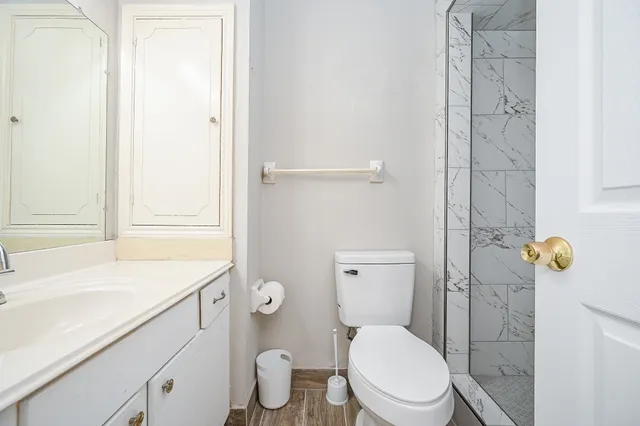 a bathroom with a sink a toilet and shower
