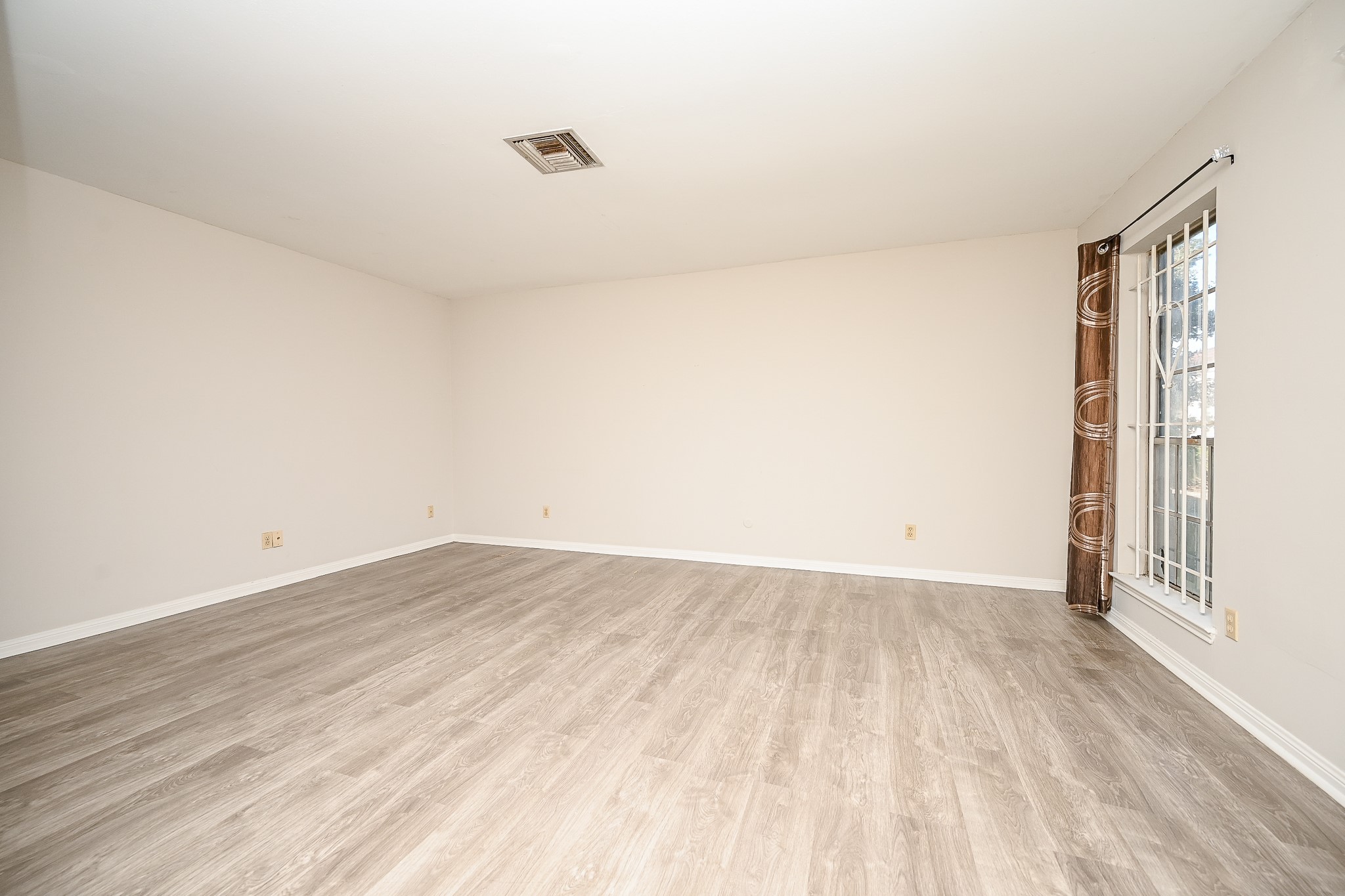 7878 Leonora Street Houston, TX 77061 - Photo 8 of 33 a view of an empty room with wooden floor and a window