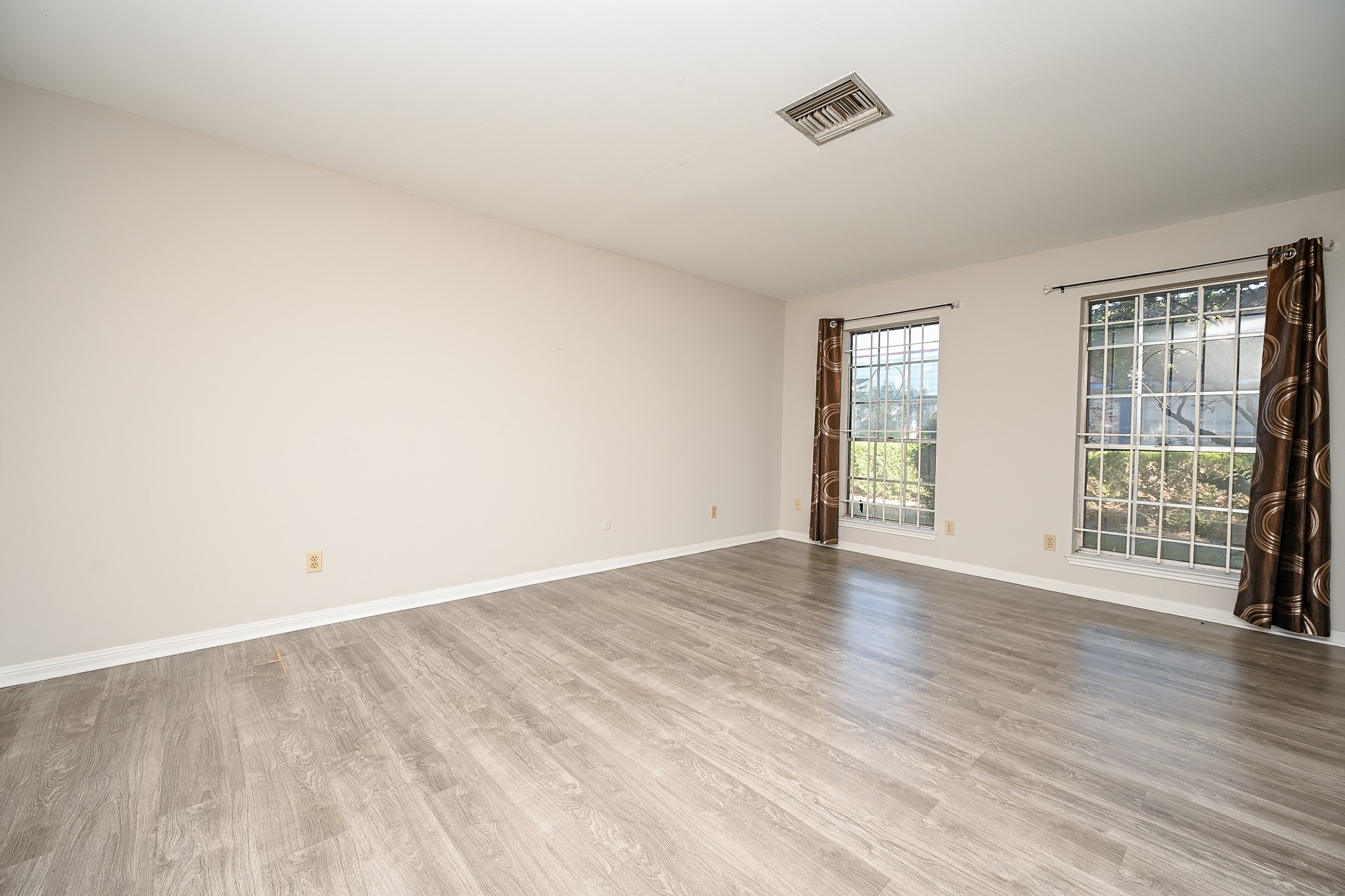 7878 Leonora Street Houston, TX 77061 - Photo 10 of 33 an empty room with wooden floor and windows