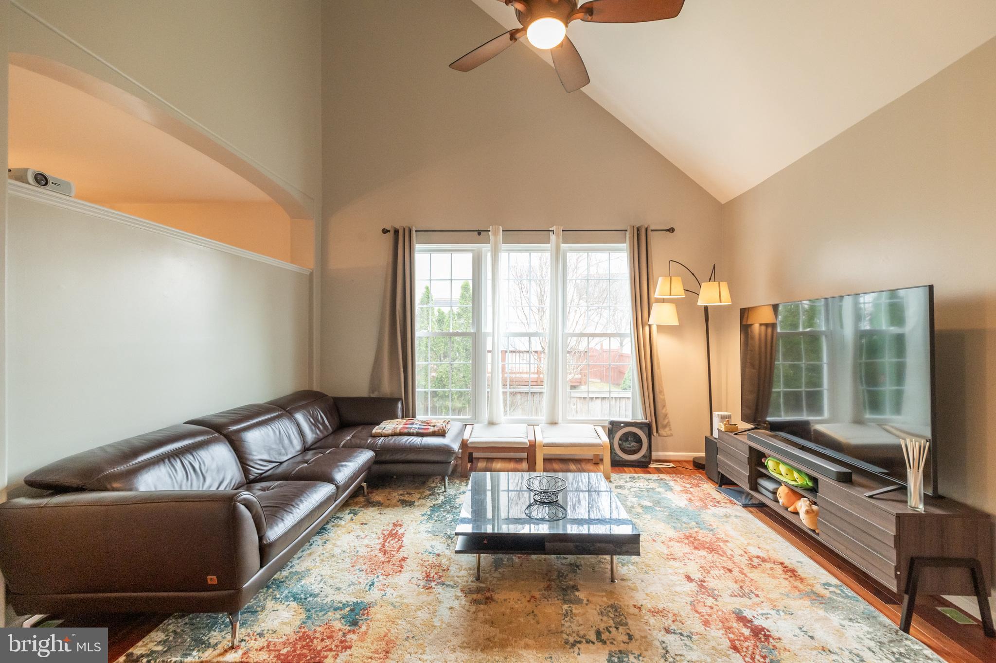 6005 Honnicut Drive Centreville, VA 20121 - Photo 8 of 29 a living room with furniture floor to ceiling window and a flat screen tv
