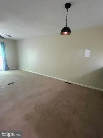 a view of a room with wooden floor and a window