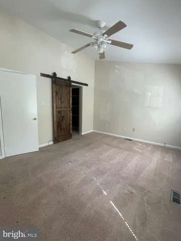 a view of a livingroom with a ceiling fan and closet area
