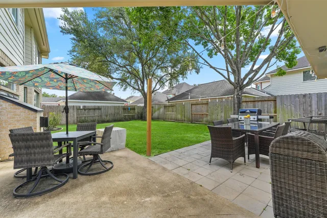 a view of a patio with table and chairs under an umbrella