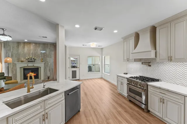 a kitchen with stainless steel appliances a sink stove top oven and cabinets