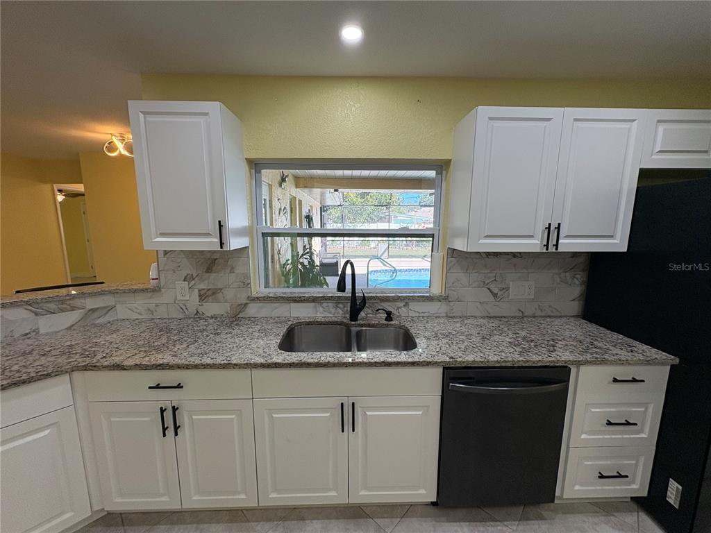 1117 Angela Maria Road Sarasota, FL 34243 - Photo 21 of 52 a kitchen with stainless steel appliances granite countertop a sink and a granite counter tops