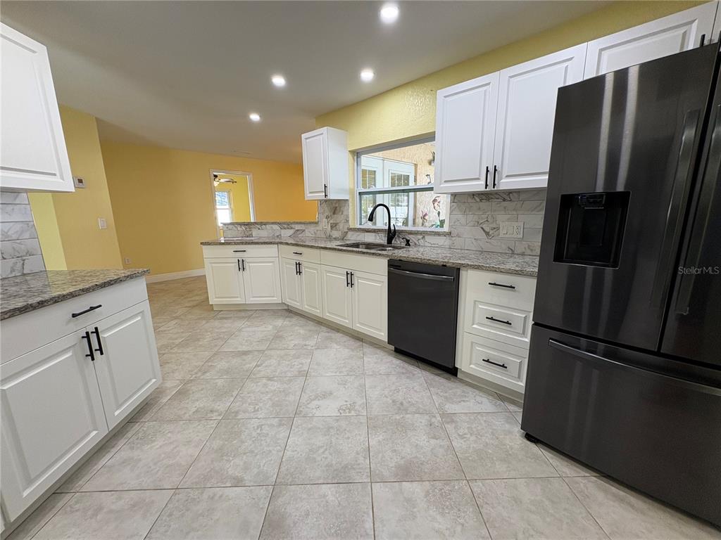 1117 Angela Maria Road Sarasota, FL 34243 - Photo 22 of 52 a kitchen with stainless steel appliances granite countertop a refrigerator sink and cabinets