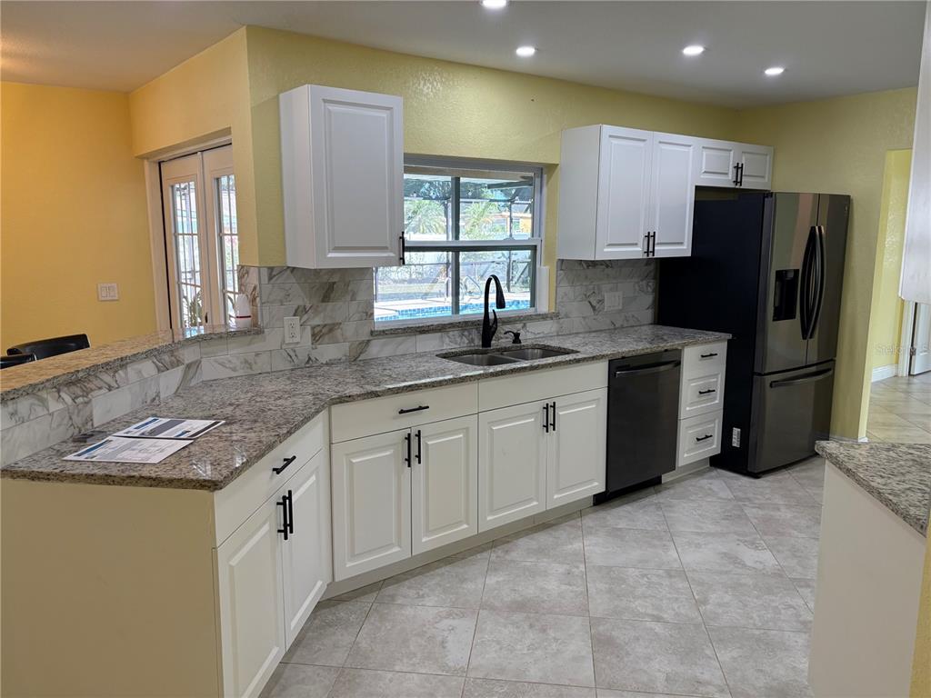 1117 Angela Maria Road Sarasota, FL 34243 - Photo 28 of 52 a kitchen with a sink stove and refrigerator