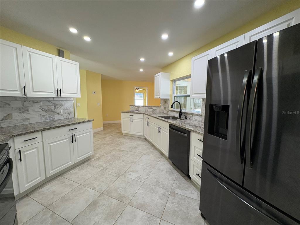 1117 Angela Maria Road Sarasota, FL 34243 - Photo 10 of 52 a kitchen with stainless steel appliances granite countertop a refrigerator sink and cabinets