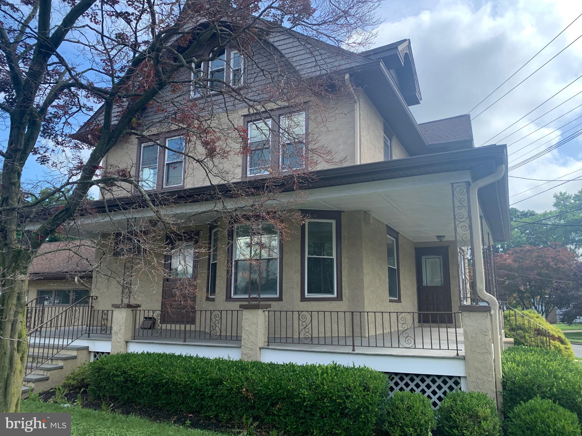a view of a house with brick walls and a yard with plants