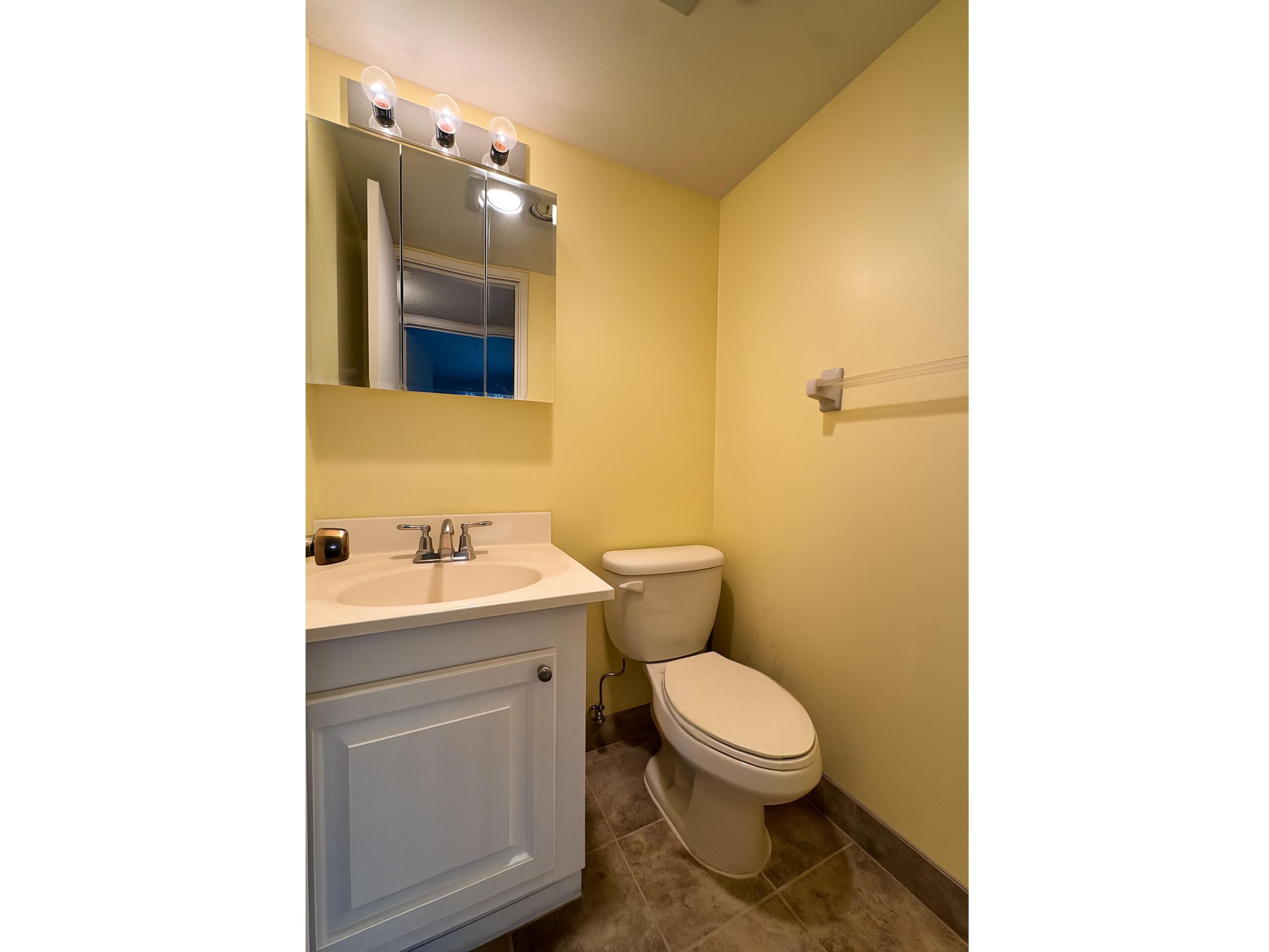 3000 Springdale Boulevard, Unit V303 Palm Springs, FL 33461 - Photo 18 of 22 a bathroom with a toilet a sink and mirror