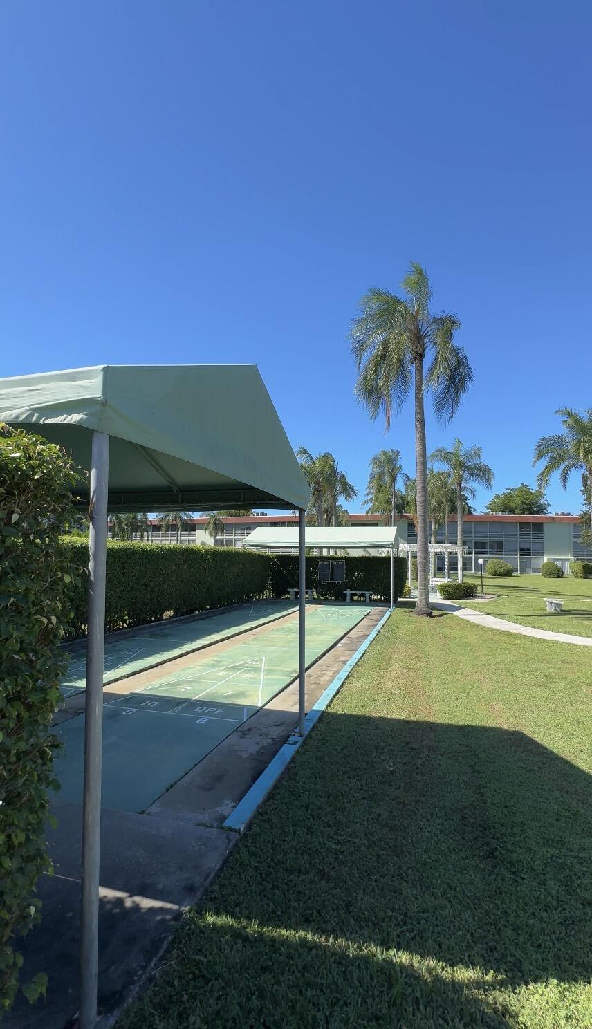 3000 Springdale Boulevard, Unit V303 Palm Springs, FL 33461 - Photo 21 of 22 a view of swimming pool with lawn chairs under an umbrella