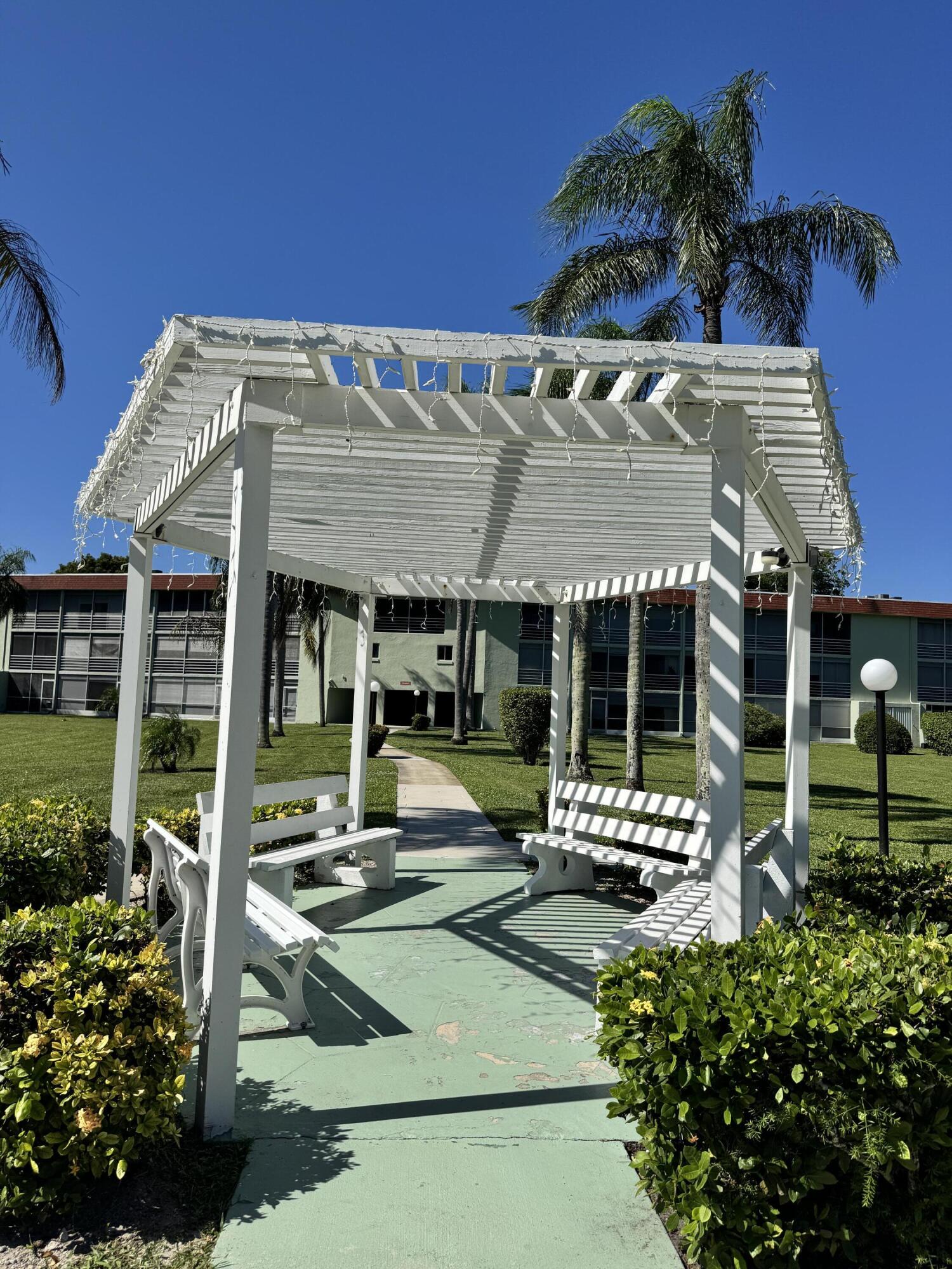3000 Springdale Boulevard, Unit V303 Palm Springs, FL 33461 - Photo 6 of 22 a view of a patio with table and chairs potted plants