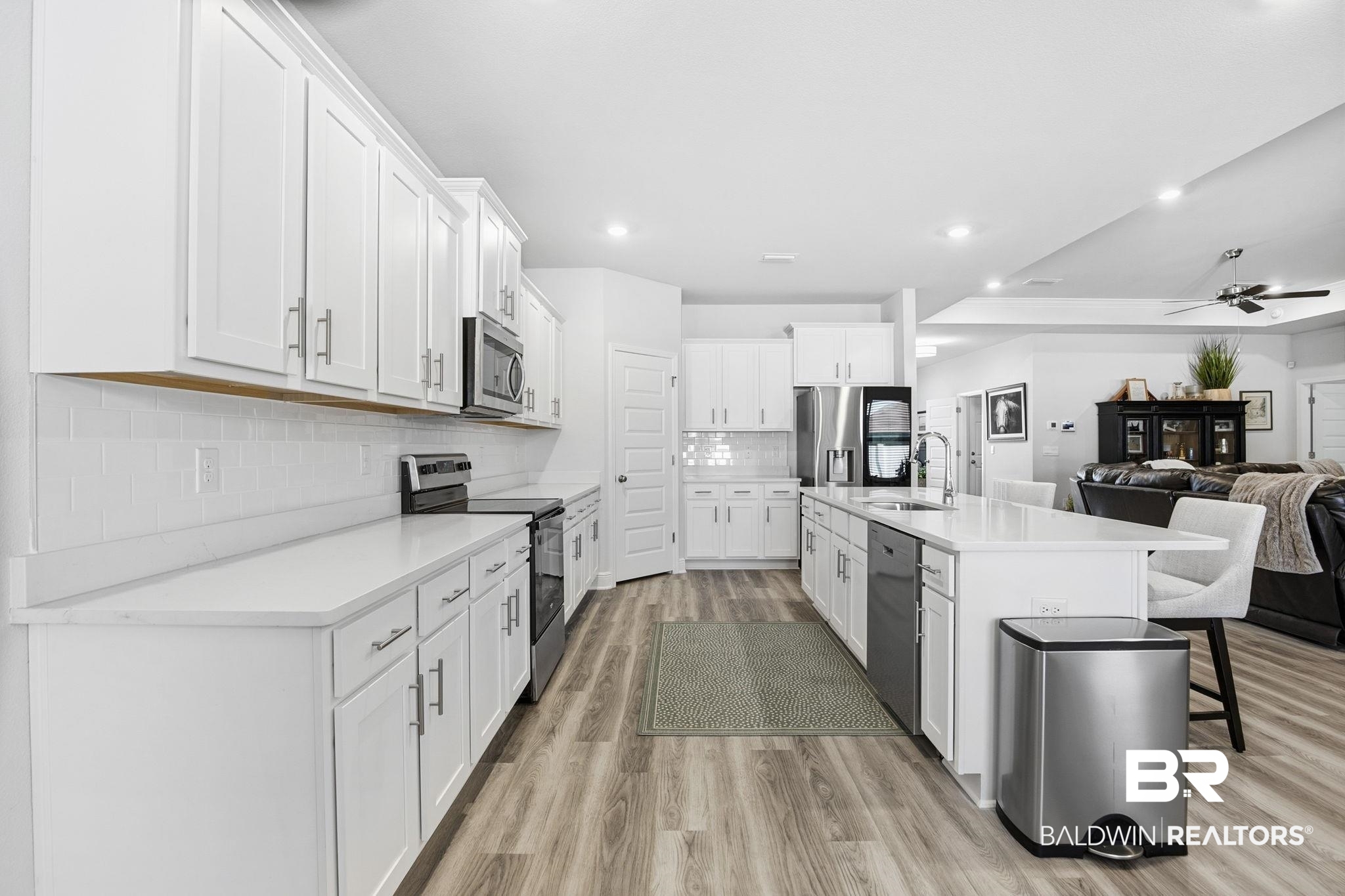 11123 Genuine Risk Circle Daphne, AL 36526 - Photo 64 of 67 Kitchen with open floor plan, stainless steel appliances, light wood-style floors, white cabinetry, and a kitchen breakfast bar