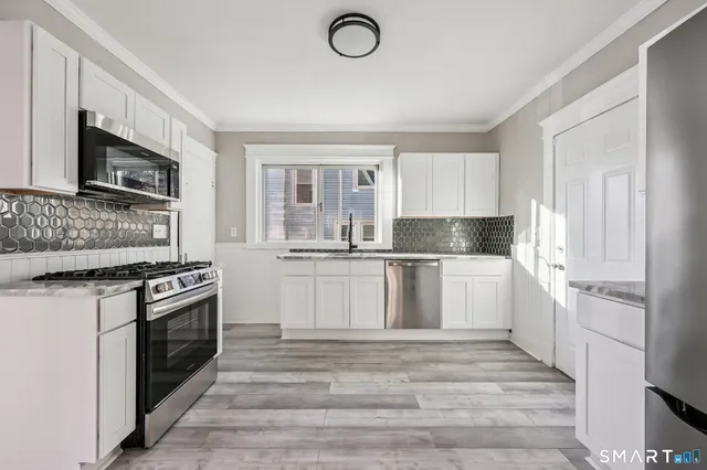 a kitchen with granite countertop a refrigerator stove and microwave