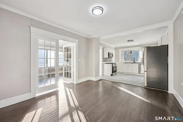a view of a kitchen with a refrigerator an empty space and a window