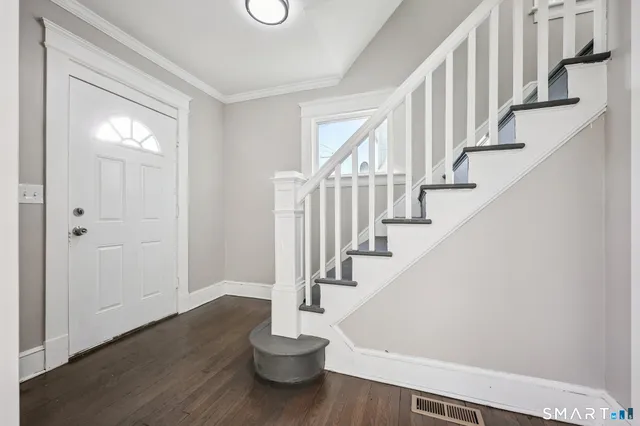 a view of entryway and hall with wooden floor