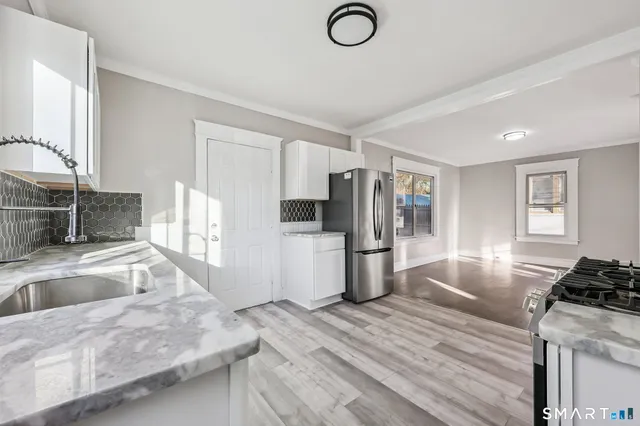 a kitchen with stainless steel appliances granite countertop a sink stove and refrigerator