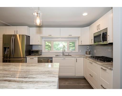 18 Austin Road Sudbury, MA 01776 - Photo 9 of 38 a kitchen with stainless steel appliances granite countertop a stove a sink a refrigerator a microwave a refrigerator and white cabinets with wooden floor