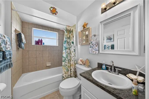 a bathroom with a granite countertop toilet a sink and a bathtub