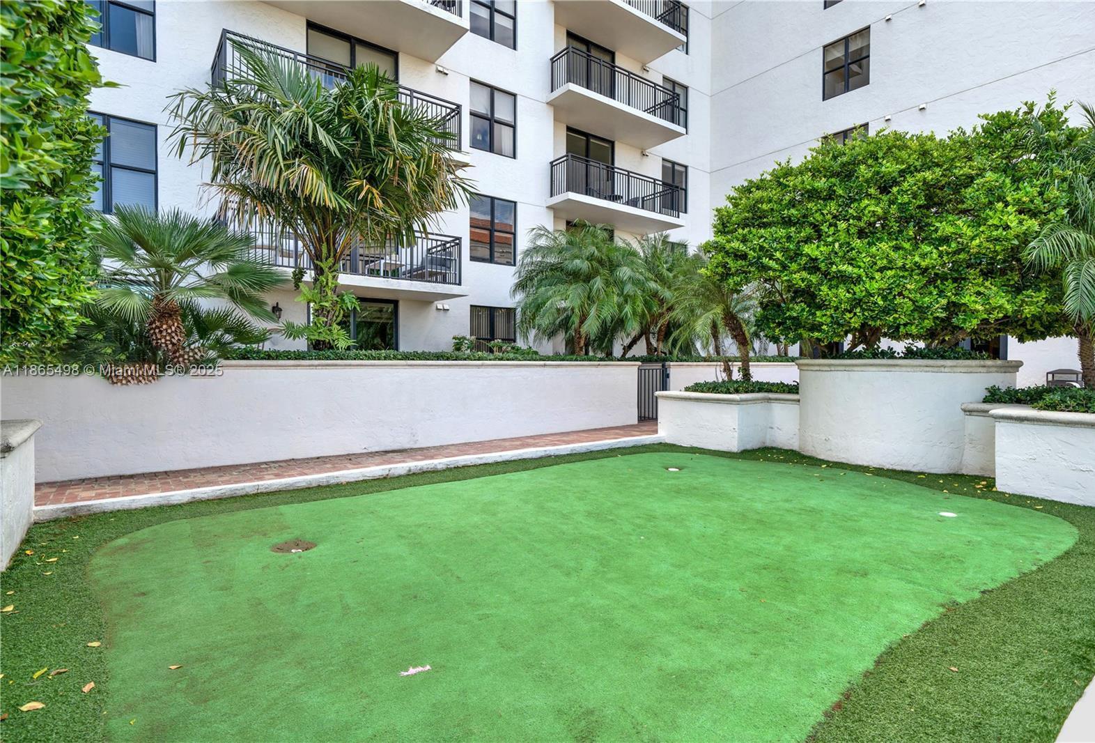 888 Douglas Road, Unit 1512 Coral Gables, FL 33134 - Photo 16 of 20 a view of a house with a yard and a large tree