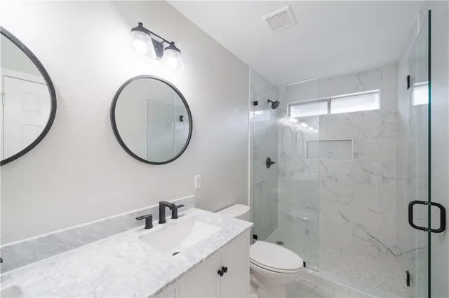 a bathroom with a sink a toilet and a mirror