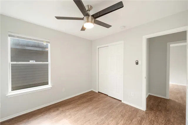 an empty room with a window and a ceiling fan