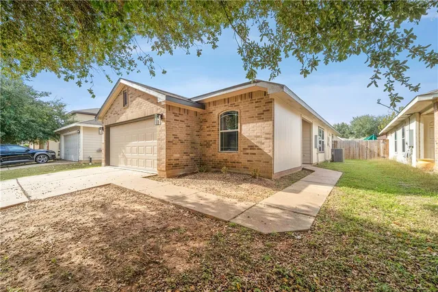 a view of a white house next to a yard with large trees
