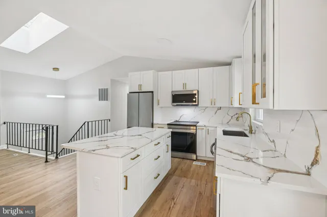 a kitchen with stainless steel appliances a refrigerator and a stove top oven