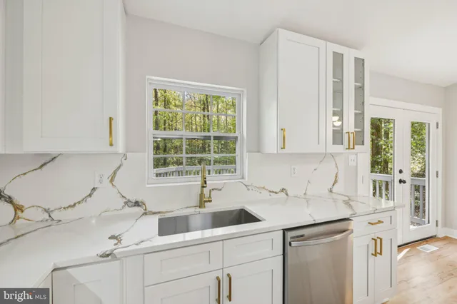 a kitchen with granite countertop a sink stove and refrigerator